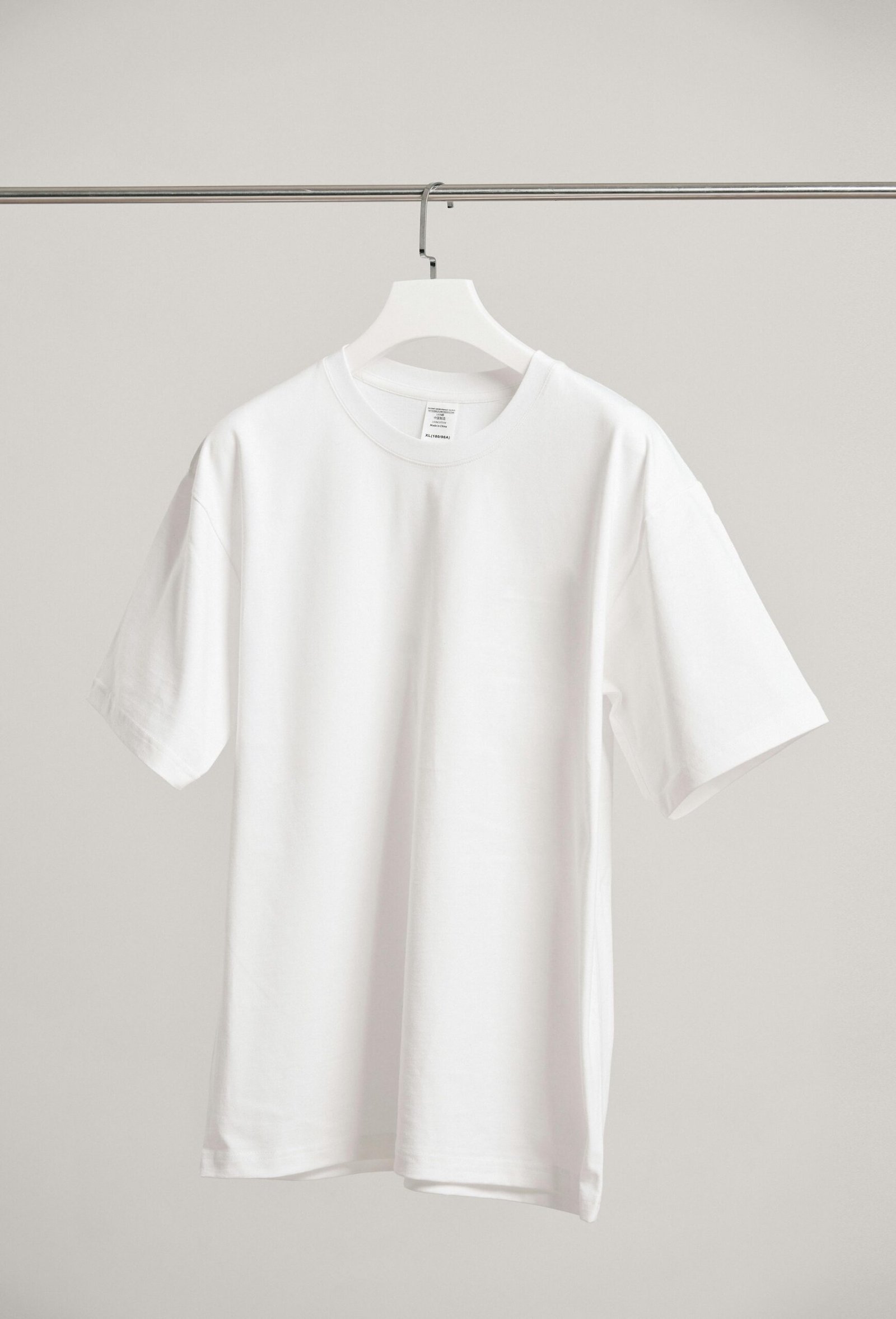 Camiseta Digital Art 2 Simple white t-shirt hanging in a modern Shanghai boutique, emphasizing fashion minimalism.