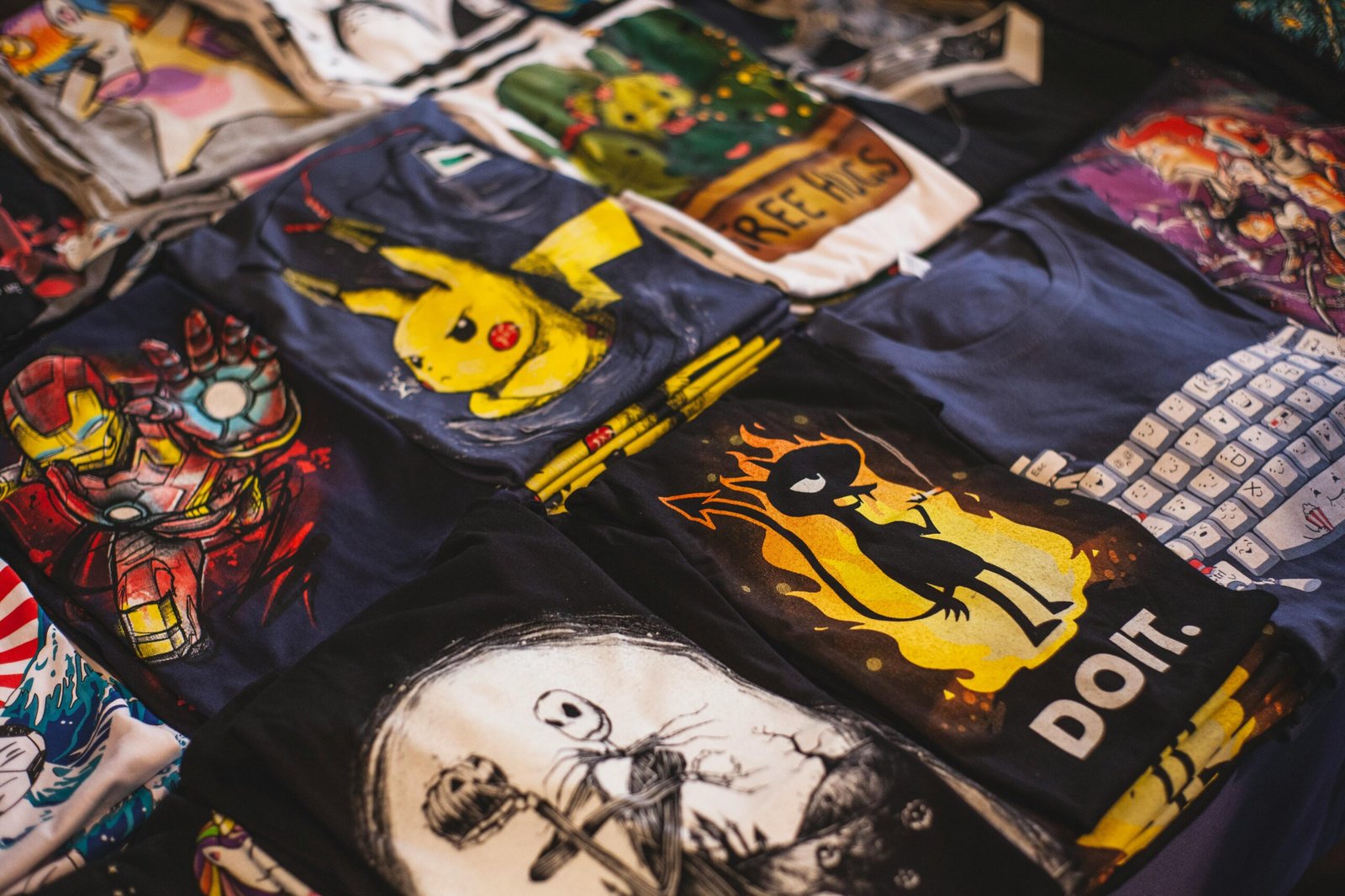Camiseta Digital Art 1 A vibrant assortment of graphic t-shirts featuring popular characters displayed in a market setting.